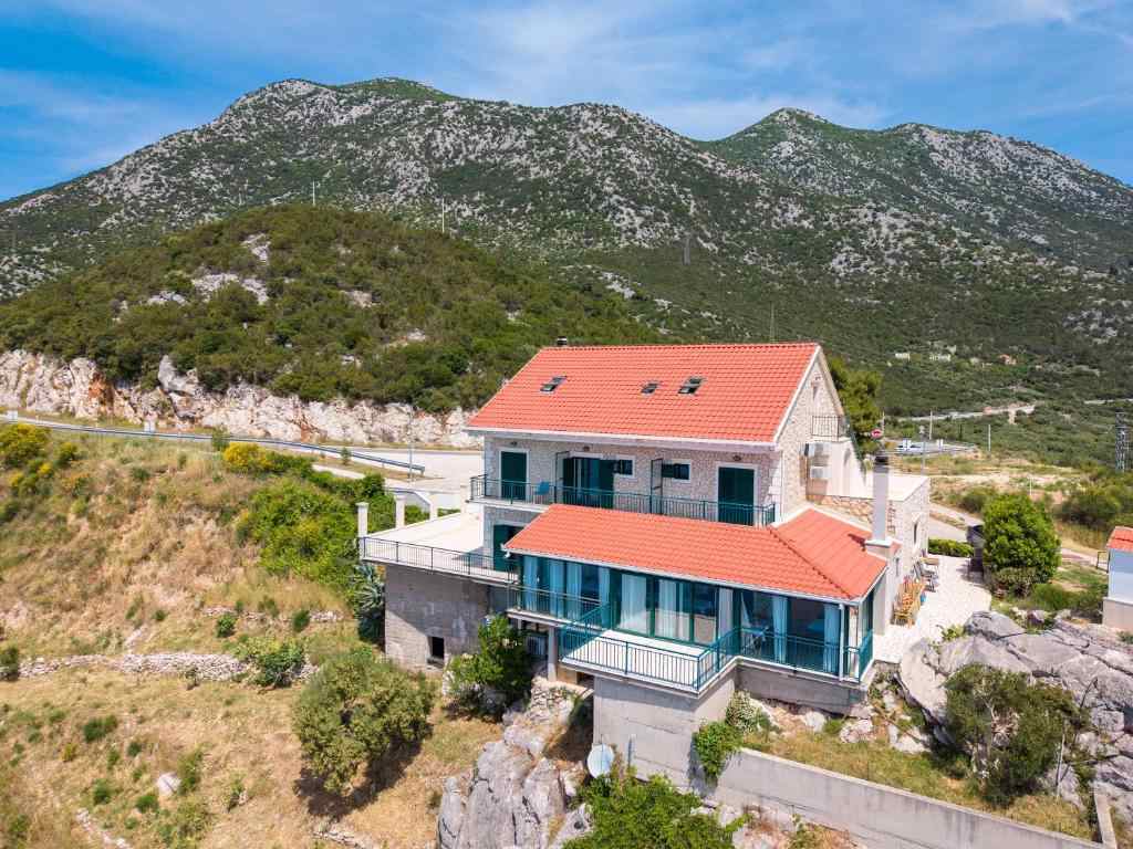 Galeb Bed and Breakfast house set against the green hills of Baćina